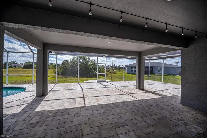 Unfurnished sunroom with track lighting