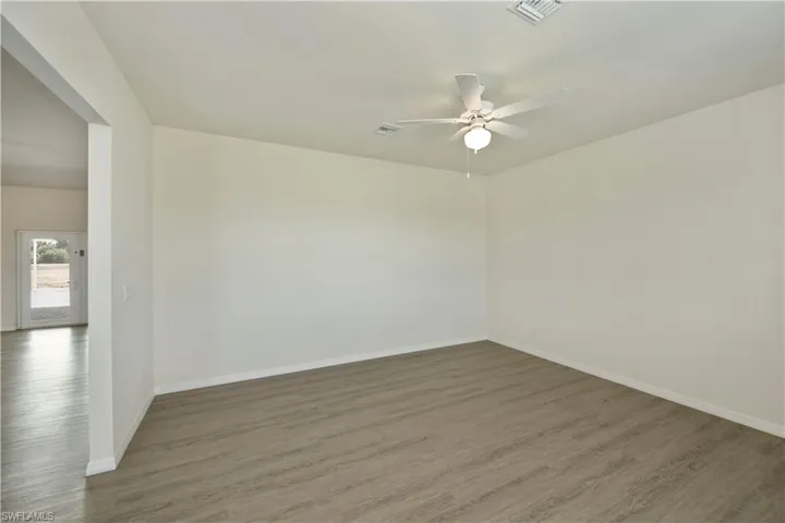 Empty room featuring a ceiling fan and wood finished floors