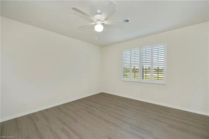 Unfurnished room featuring wood finished floors and a ceiling fan