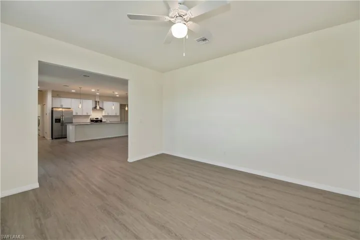 Unfurnished living room with light wood-type flooring and ceiling fan