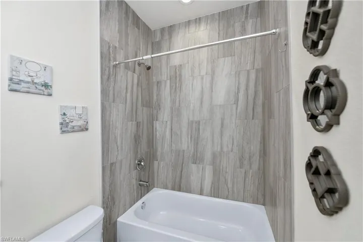 Full bathroom with toilet and bathing tub / shower combination