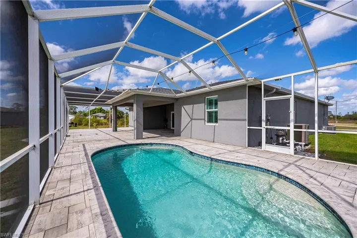 Outdoor pool with a patio and a lanai