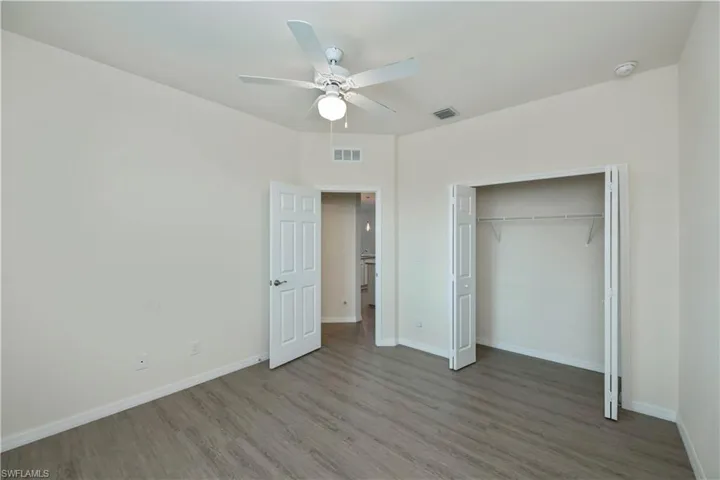 Unfurnished bedroom featuring wood finished floors, a closet, and a ceiling fan
