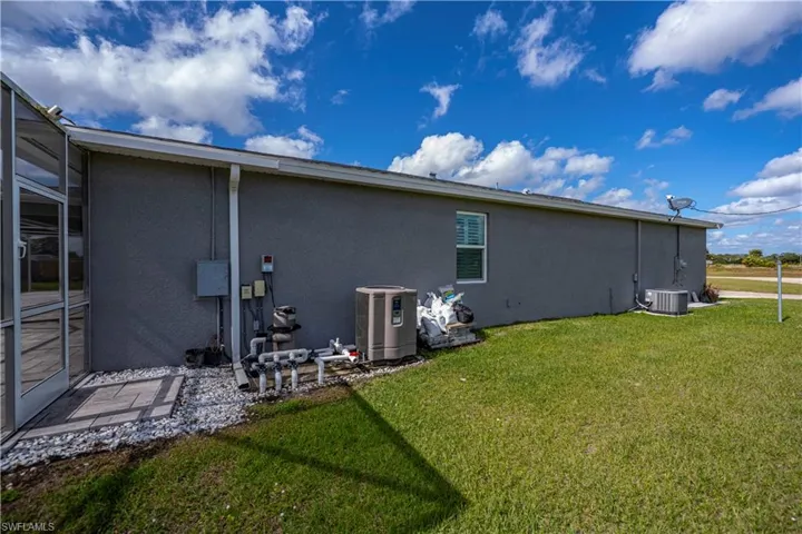 Rear view of property with stucco siding and a yard