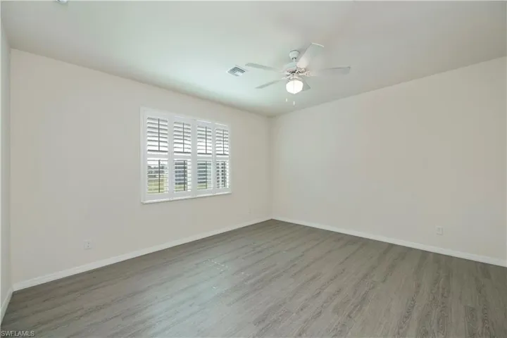 Spare room with wood finished floors and a ceiling fan