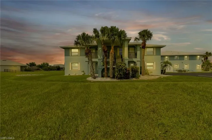View of front of house featuring a lawn and a balcony