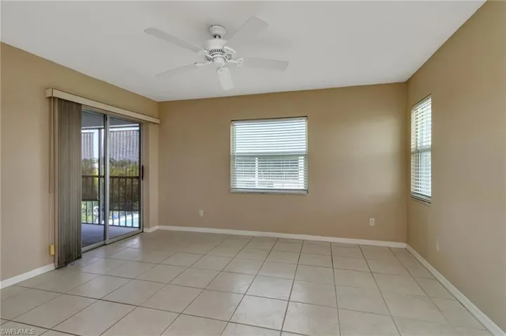 Empty room with ceiling fan and light tile patterned floors