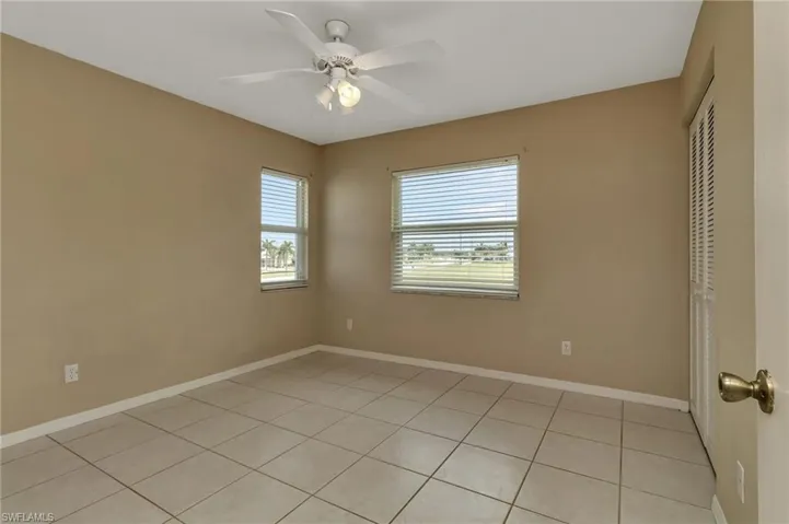 Tiled empty room featuring ceiling fan