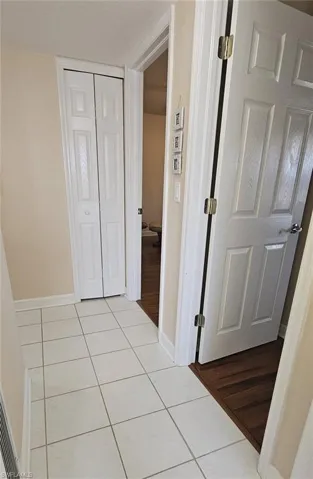 Corridor featuring light tile patterned floors and baseboards