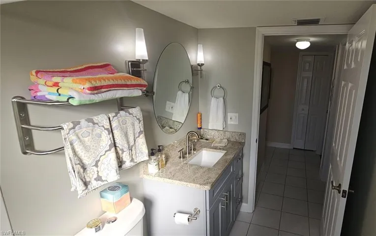 Half bath with vanity and light tile patterned floors