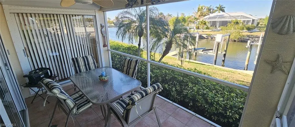 Balcony featuring a water view, outdoor dining space, and ceiling fan