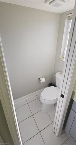 Bathroom with toilet and light tile patterned floors