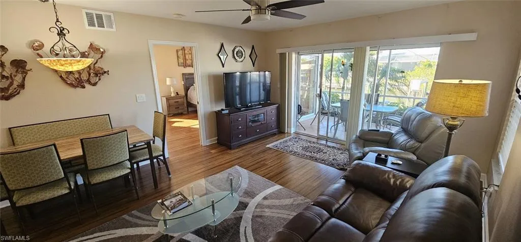 Living area featuring dark wood finished floors and ceiling fan