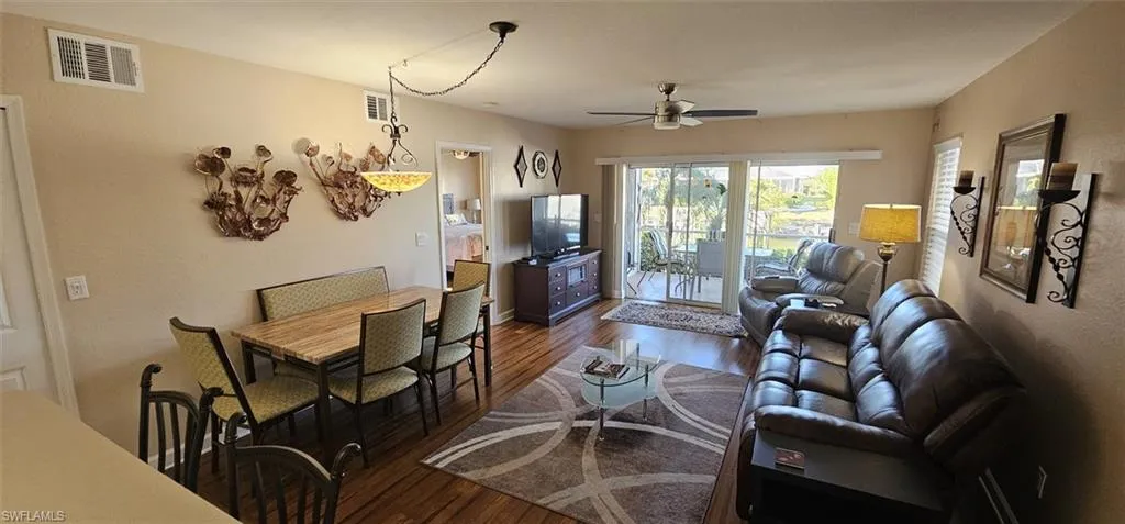 Living room featuring dark wood-style floors and ceiling fan