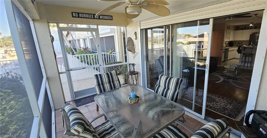 Sunroom / solarium featuring a ceiling fan and outdoor dining space
