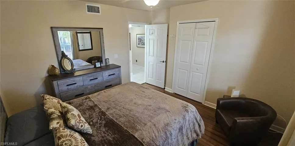 Bedroom featuring dark wood finished floors, a closet, and ceiling fan