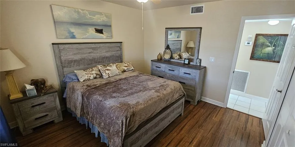 Bedroom featuring dark wood-type flooring and baseboards