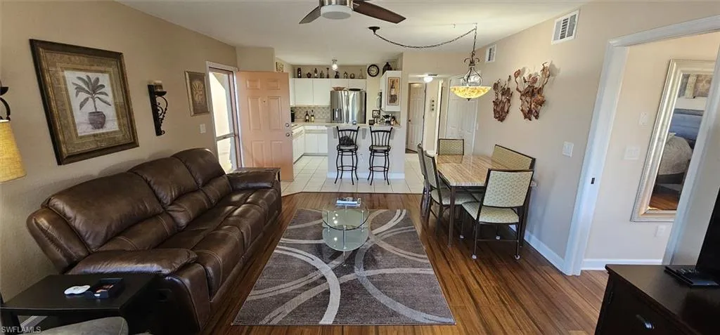 Living room with dark wood-type flooring and ceiling fan