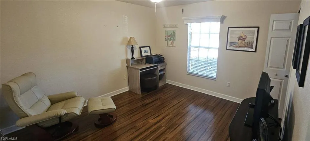 Living area with dark wood-type flooring and baseboards
