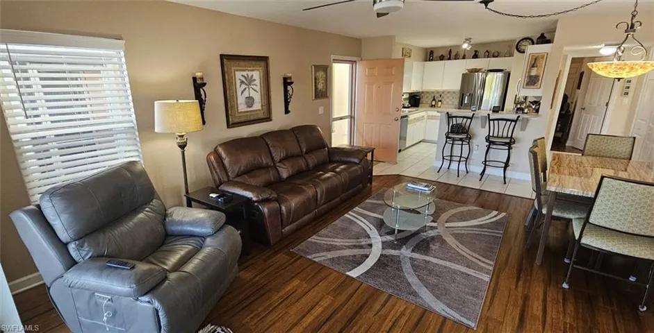Living room with dark wood-style floors and plenty of natural light
