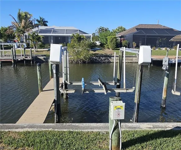 Dock featuring boat lift, a water view, and a sunroom