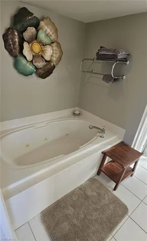 Bathroom featuring light tile patterned floors and a jetted tub