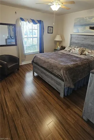 Bedroom with dark wood-style flooring and a ceiling fan