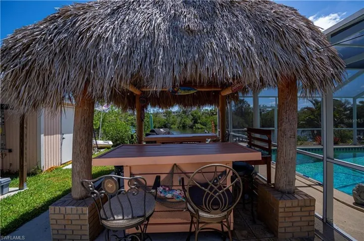 View of patio with a gazebo, an outdoor pool, and glass enclosure