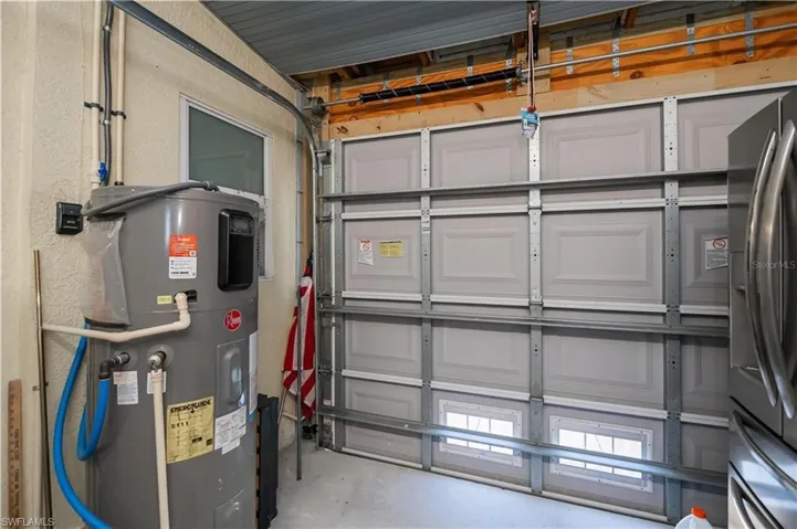 Garage with water heater and stainless steel refrigerator