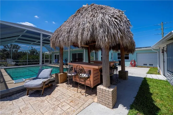 View of patio with glass enclosure, a sunroom, and an outdoor pool