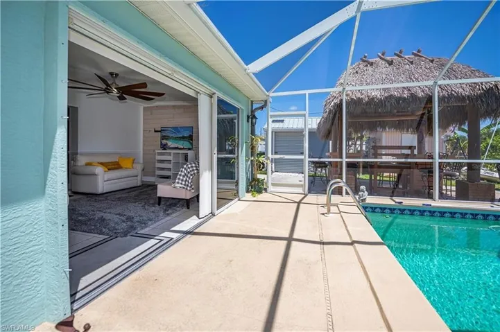 Outdoor pool with a patio, glass enclosure, a sunroom, and ceiling fan