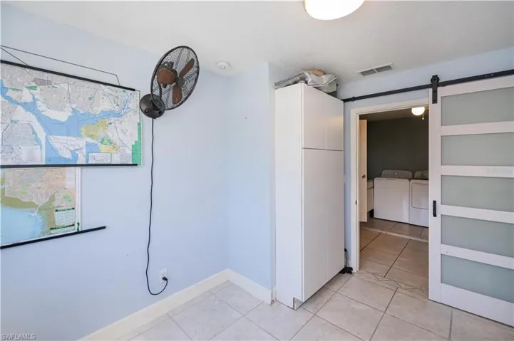 Spare room with light tile patterned floors, a barn door, and washing machine and clothes dryer