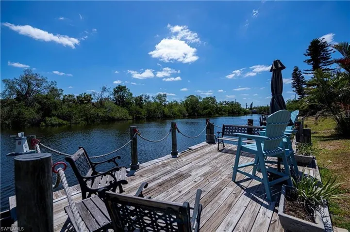 Dock with view of scattered trees and a deck with water view