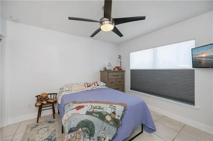 Bedroom with light tile patterned floors and ceiling fan