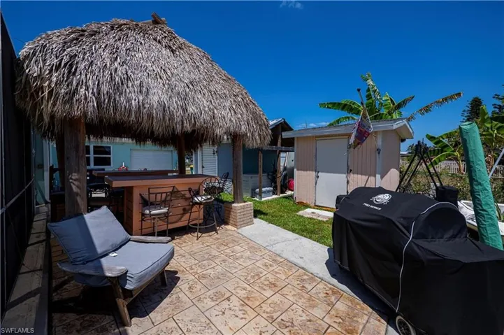 View of patio featuring a gazebo, area for grilling, and a storage unit