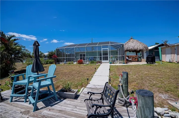Back of property with a lawn, a sunroom, a patio area, and glass enclosure