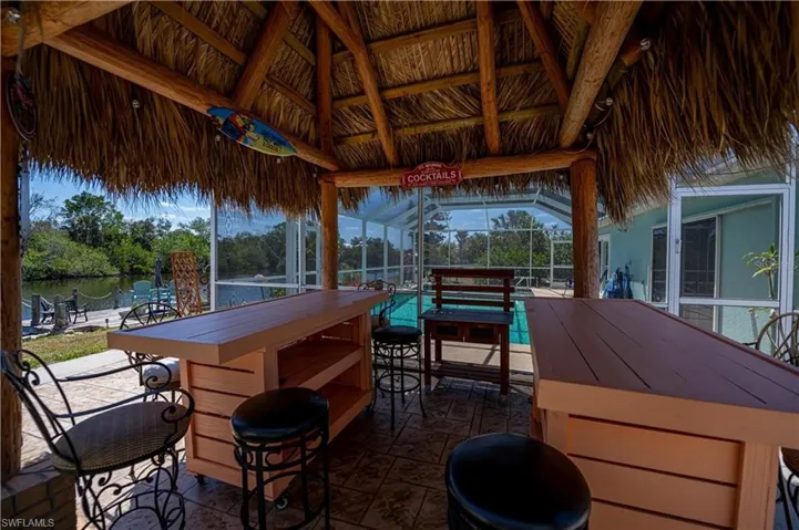 Wooden deck featuring a water view, glass enclosure, a pool, and a sunroom