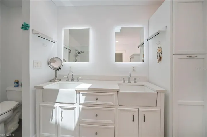 Bathroom featuring double vanity and a shower with shower door