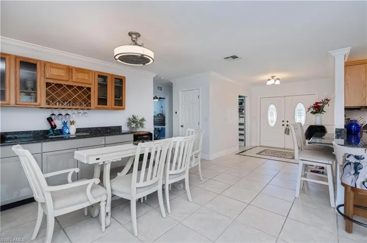 Dining space with light tile patterned floors and ornamental molding