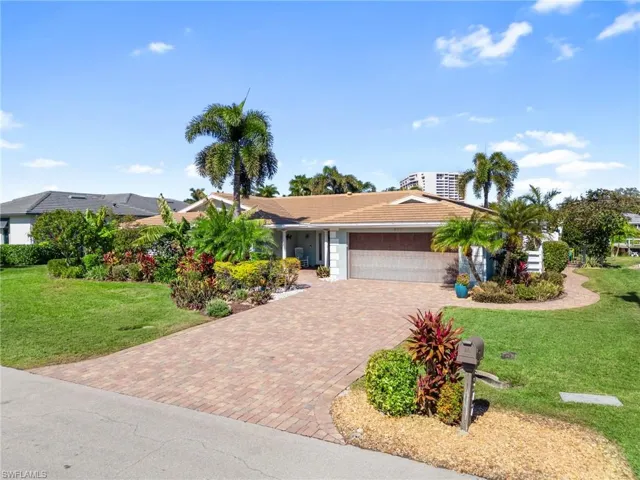 Ranch-style house with a front lawn, driveway, and a garage