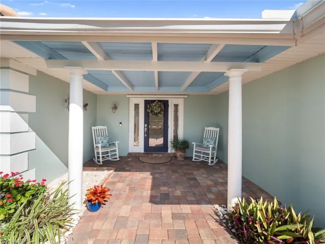 Entrance to property with a porch and stucco siding