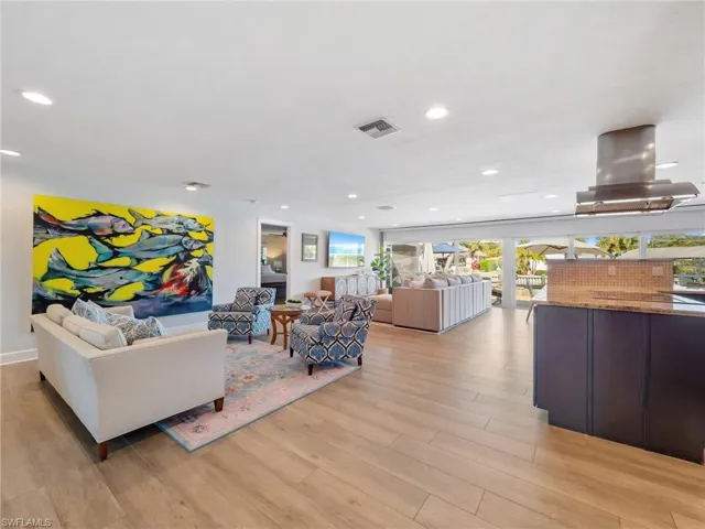 Living room with light wood-style flooring and recessed lighting