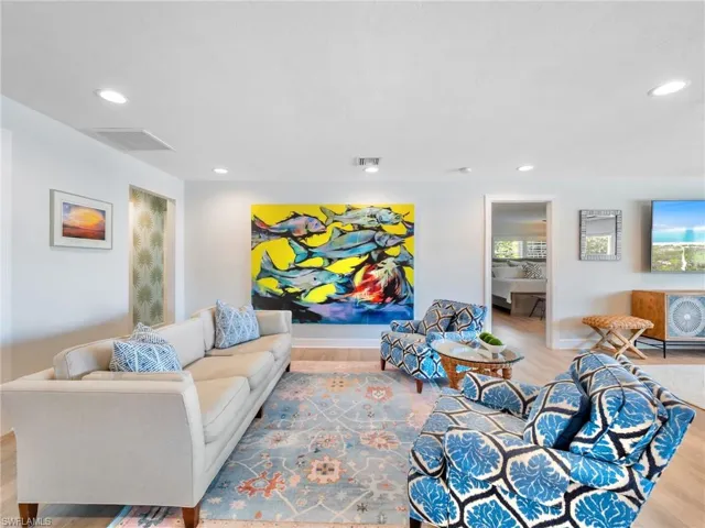 Living area with light wood-style floors and recessed lighting