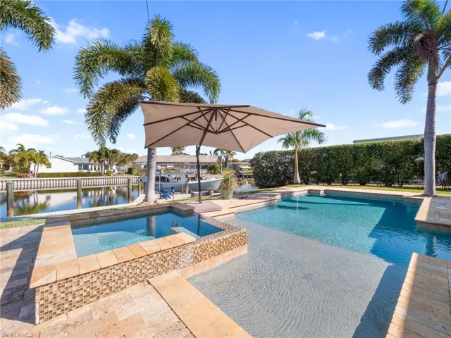 Relaxing pool / spa featuring a water view and a dock