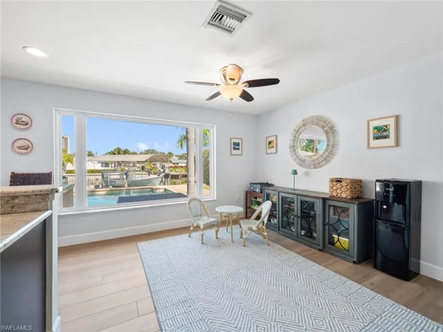 Living area with light wood finished floors and ceiling fan