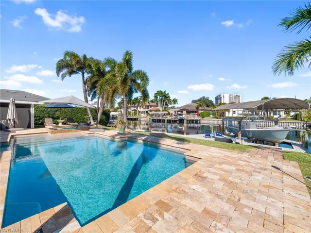 Swimming pool featuring an in-ground hot tub, a boat dock, a patio, a water view, and boat lift