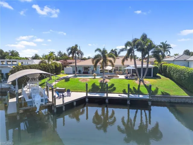 Dock featuring a water view, boat lift, and an outdoor pool