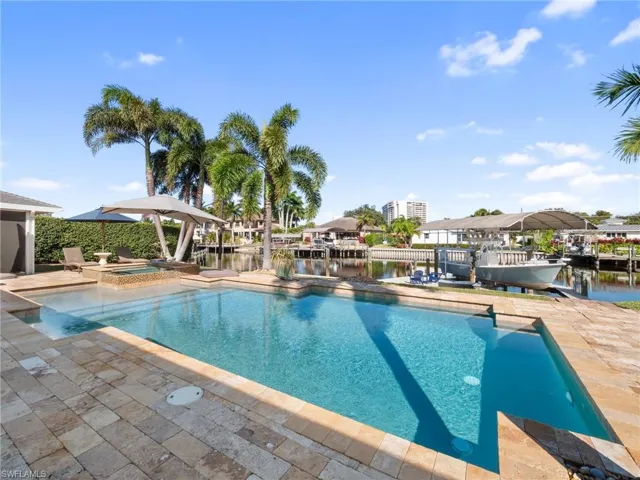 Relaxing pool / spa with a water view and a patio area