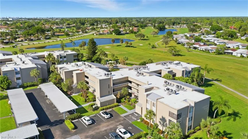 Aerial perspective of suburban area with a nearby body of water and a golf club