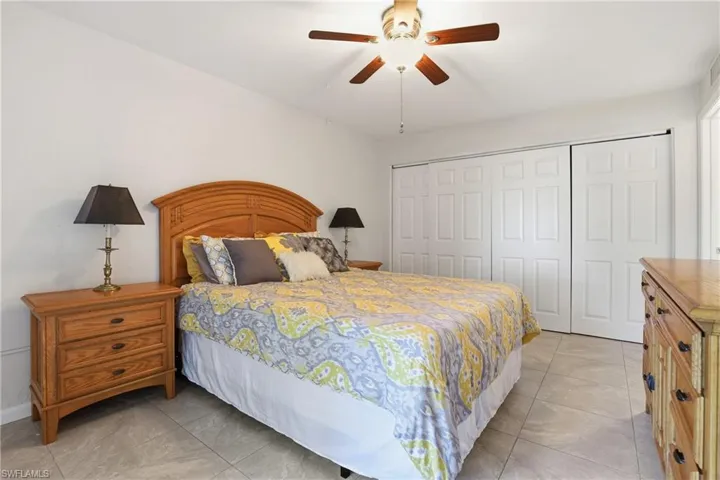 Bedroom with a closet, ceiling fan, and light tile patterned floors
